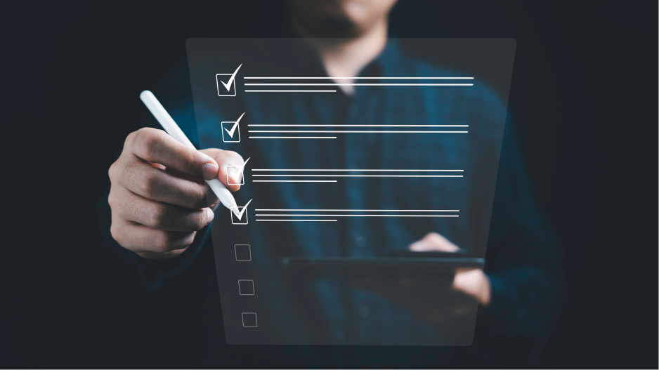 /_cms/webroot/A man holds a tablet and uses a pen to mark a digital checklist with several points ticked off.